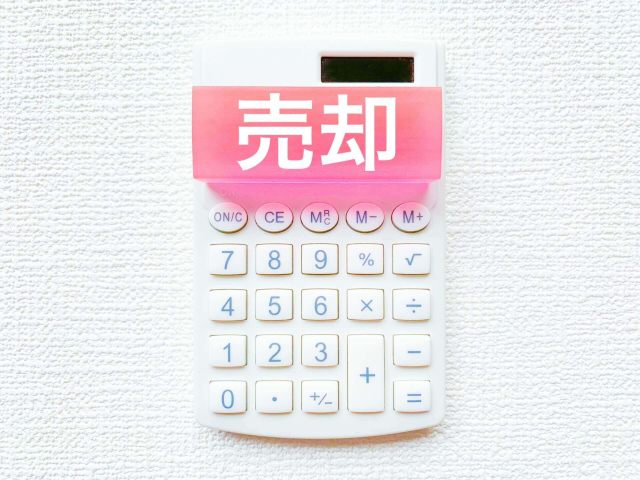 電卓の上にある売却の文字